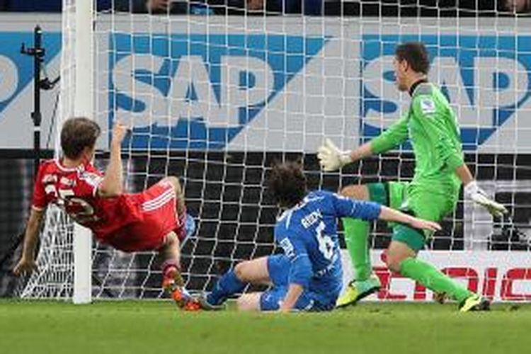 Gelandang Bayern Muenchen, Thomas Mueller (kiri) mencetak gol untuk membuat timnya menang 2-1 atas Hoffenheim, Sabtu (2/11/2013) dalam laga Bundesliga. Tampak kiper Hoffenheim, Koen Casteels (kanan) dan gelandang Sebastian Rudy (tengah) berusaha menghalangi Mueller.