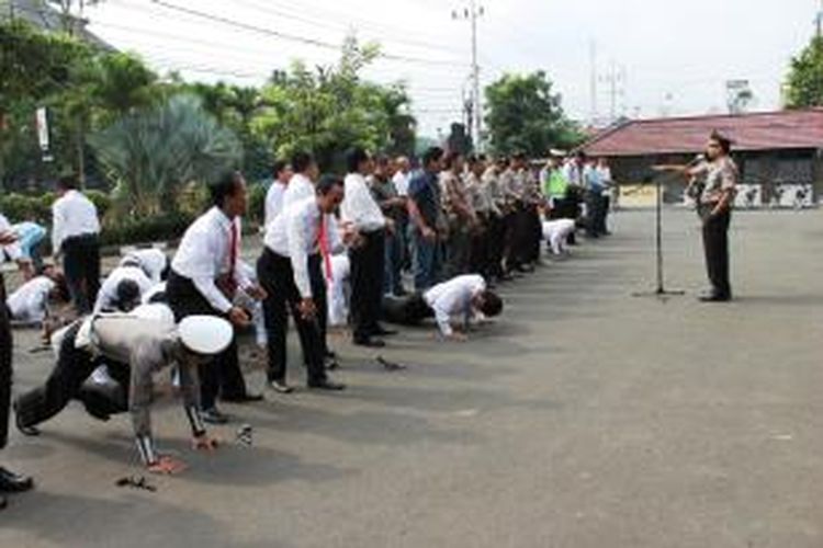 Sejumlah anggota Polres Malang Kota menerima hukuman push up dari Wakil Kapolres Kompol Tri Saksono Puspo Aji karena pistol mereka kedapatan dalam keadaan kotor, Senin (25/11/2013). 
