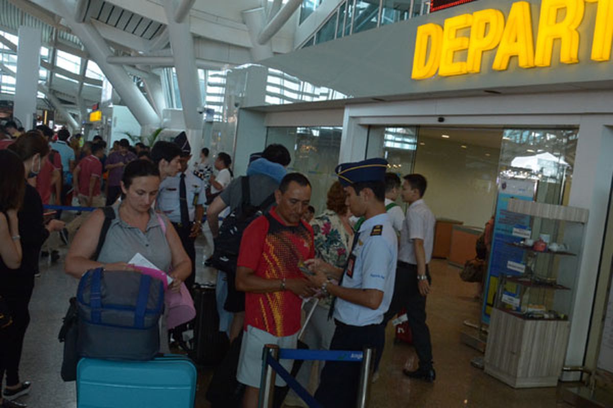 Petugas memeriksa tiket penumpang di Bandara Ngurah Rai Bali, Rabu (29/11/2017).  