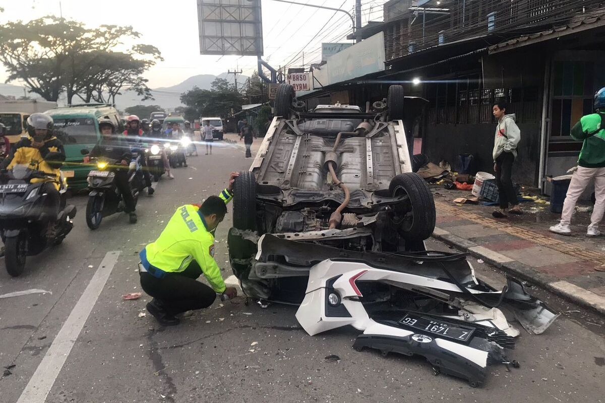 Salah seorang petugas tengah melakukan proses penyelidikan sebuah kecelakaan di Jalan Raya Bandung-Garut, Kabupaten Bandung, Jawa Barat pada Kamis (13/2/2025) dini hari tadi