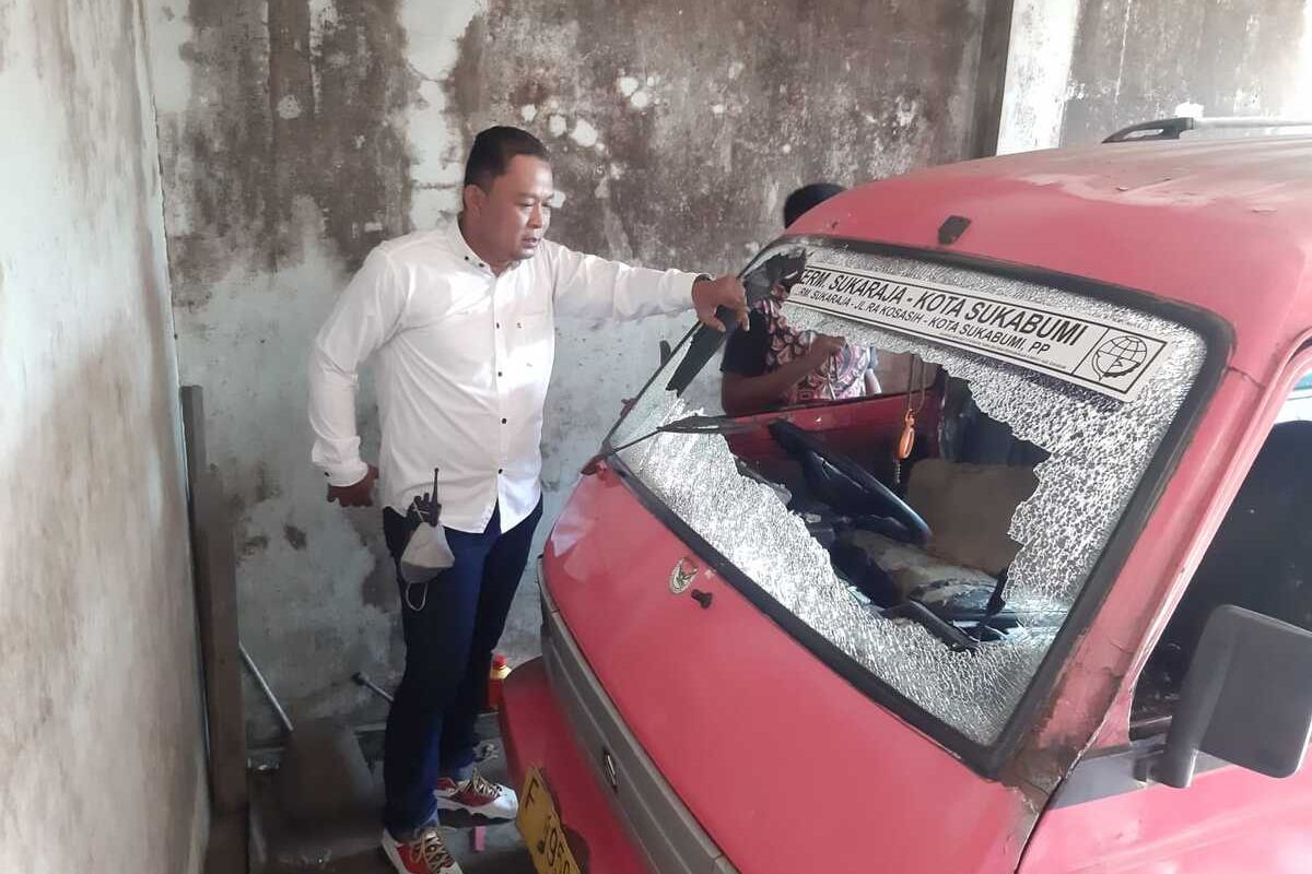Kepala Satuan Reserse Kriminal Polsek Cikole Ipda Gungun Gunawan mengecek mobil angkutan kota yang rusak dilempar es batu di Sukabumi, Jawa Barat, Jumat (19/8/2022).