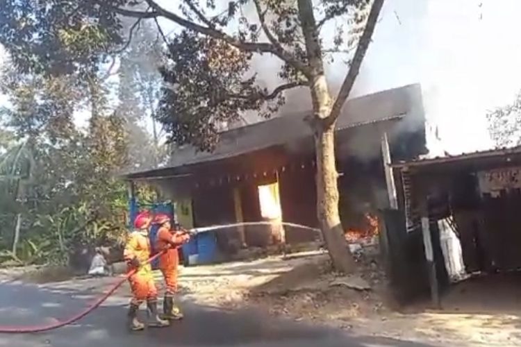 Petugas berupaya memadamkan api yang membakar tempat pengoplosan bahan kimia