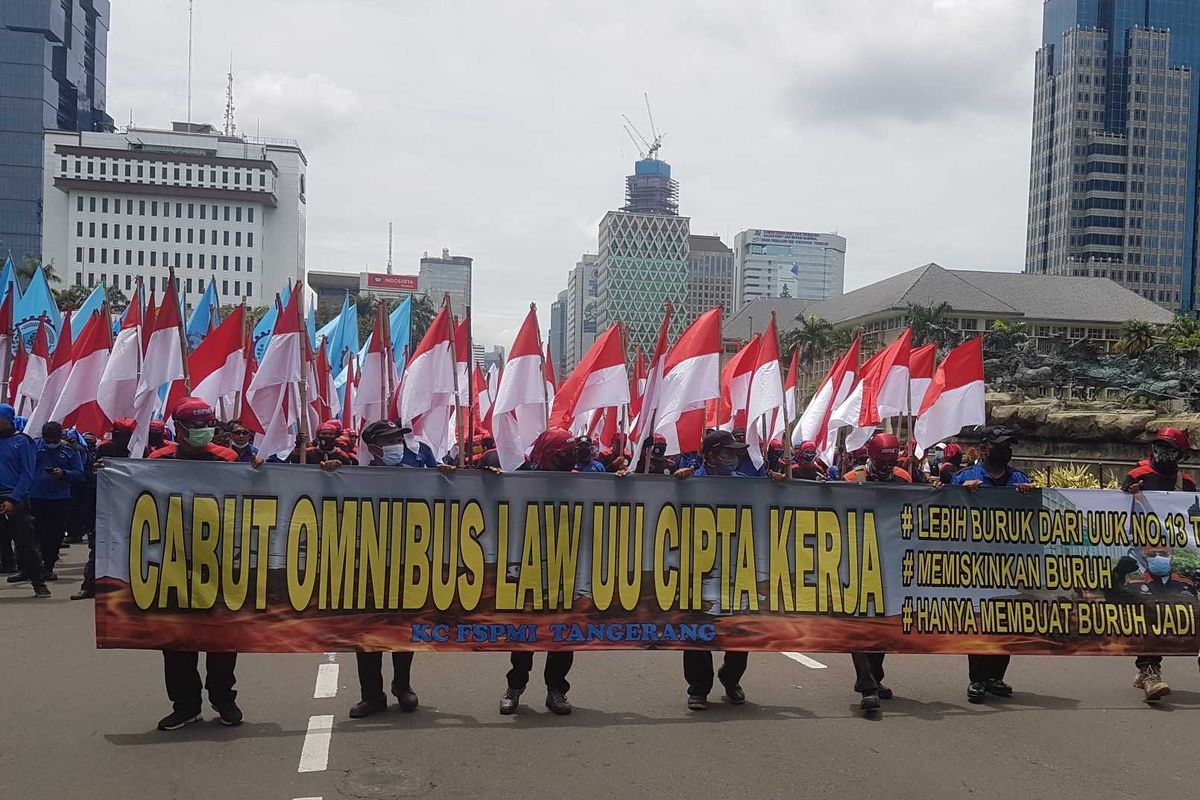 Massa Buruh Membawa spanduk yang menyerukan penolakan pada Omnibus Law UU Cipta kerja, pada aksi unjuk rasa, Senin (2/11/2020) di sekitar Patung Kuda Arjuna Wiwaha, Jakarta Pusat.