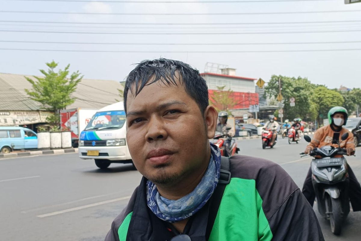 Dedy Mulyadi (30), pengemudi ojek online saat ditemui Kompas.com di dekat mal PGC, Cililitan, Jakarta Timur, Rabu (11/10/2023). Dedy merupakan salah satu pegemudi ojol yang merasa keberatan dengan wacana penerapan ganjil-genap untuk sepeda motor.