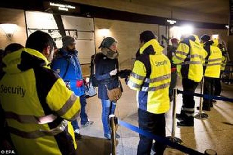 Petugas keamanan memeriksa kartu identitas para calon penumpang kereta api di stasiun kereta di luar Copenhagen, Denmark.