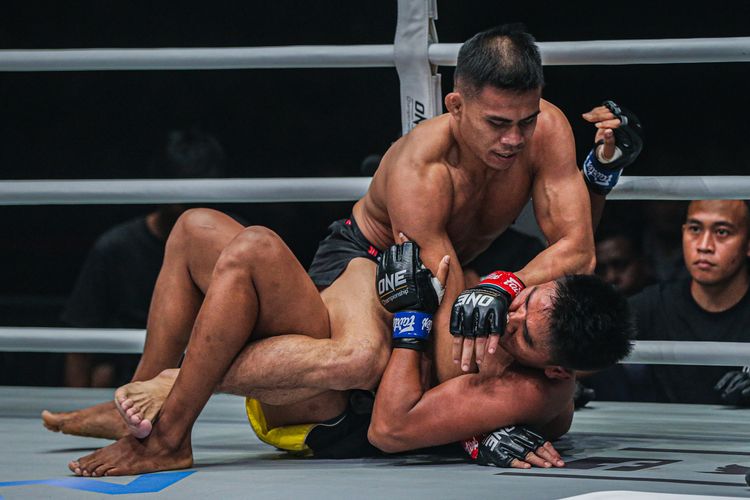 Petarung Indonesia, Eko Roni Saputra (atas) saat berduel dengan wakil Kamboja, Khon Sichan, di kelas Flyweight. pada ajang ONE Championship: Warriors Code di Istora Senayan, Jumat 7 Februari 2020.