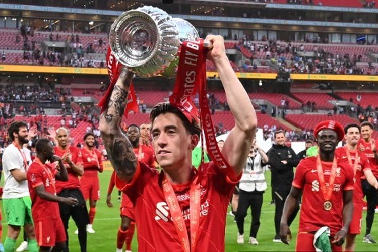 Liverpool's Greek defender Kostas Tsimikas celebrates with the trophy after winning the English FA Cup final football match between Chelsea and Liverpool, at Wembley stadium, in London, on May 14, 2022. (Photo by Glyn KIRK / AFP)