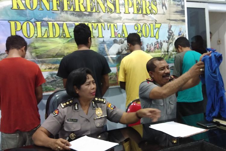 Kasubdit III Direskrimum Polda NTT, Kompol Alexander Aplugi (kanan) sedang menunjukan baju milik Benediktus Takene yang robek akibat dianiaya. Terlihat empat orang pelaku dalam posisi berbalik badan