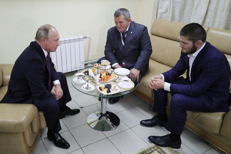 Presiden Rusia Vladimir Putin menemui petarung UFC Khabib Nurmagomedov (kanan) dan ayahnya Abdulmanap (tengah) di Ulyanovsk Rabu (10/10/2018). Nurmagomedov menjadi juara kelas ringan UFC setelah mengalahkan Conor McGregor pekan lalu. Namun, pertarungan berubah menjadi kericuhan karena Nurmagomedov melompati arena dan menyerang tim McGregor, Dillon Danis.