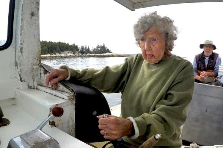 Virginia Oliver (101 tahun), mengemudikan kapal putranya Max Oliver, Selasa, 31 Agustus 2021, di lepas pantai Rockland, Maine. Oliver adalah nelayan lobster tertua di negara bagian dan mungkin yang tertua di dunia.