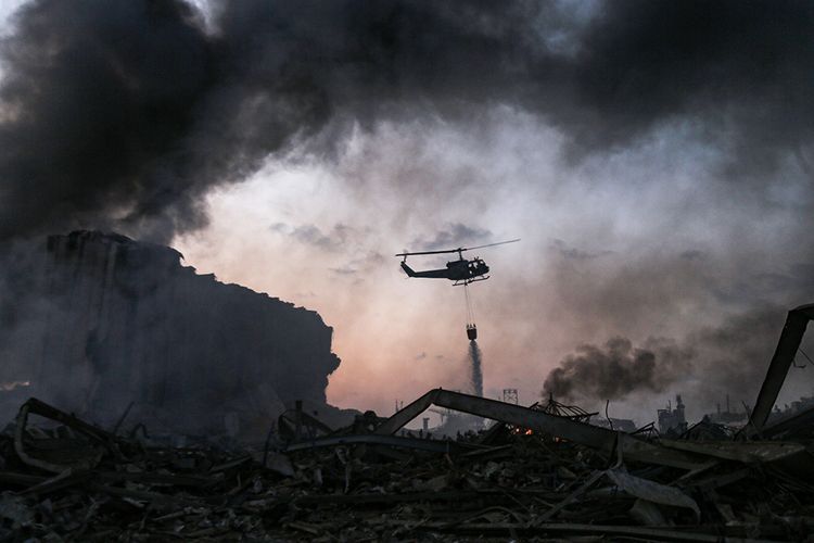 Helikopter memadamkan api di lokasi ledakan di kawasan pelabuhan di Beirut, Ibu Kota Lebanon, Selasa (4/8/2020). Sebanyak 73 orang tewas dan ribuan lainnya dilaporkan terluka dari insiden dua ledakan besar yang mengguncang Beirut tersebut.