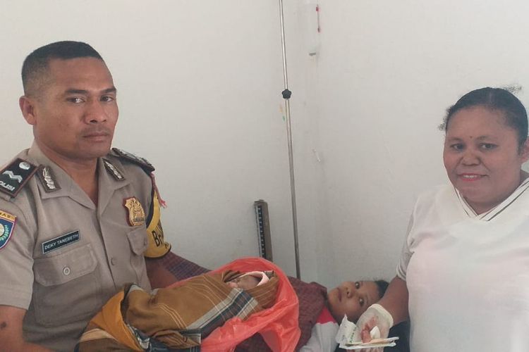 Aipda Deky Tanebeth (41), saat menggendong bayi yang dilahirkan Antoneta Banu, seorang ibu rumah tangga asal Kelurahan Naimata, Kecamatan Maulafa, Kota Kupang, NTT