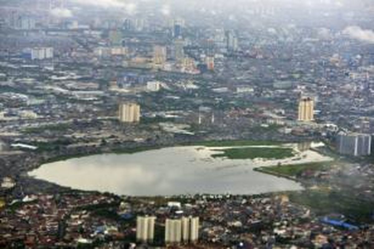 Kondisi Waduk Pluit di Kecamatan Penjaringan, Jakarta Utara, Minggu (4/1/2015). Relokasi warga penghuni rumah semipermanen di sisi timur Waduk Pluit akan dipercepat karena rumah-rumah tersebut rawan ambrol seiring cuaca ekstrem dan hujan lebat.