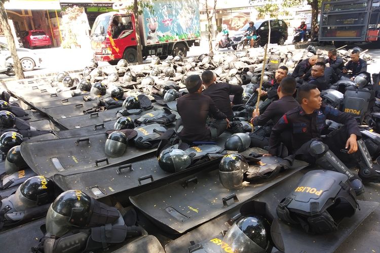 Polisi beristirahat mengantisipasi demo di Mataram, NTB. 