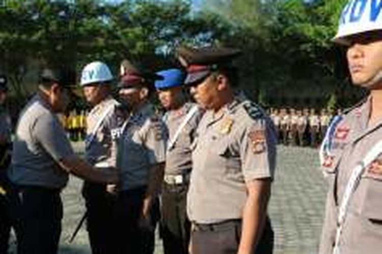 Kapolda Sultra Brigjen Pol Agung Sabar Santosa menanggalkan baju seragam dua anggota polisi yang dipecat dalam apel pagi di Mapolda Sultra