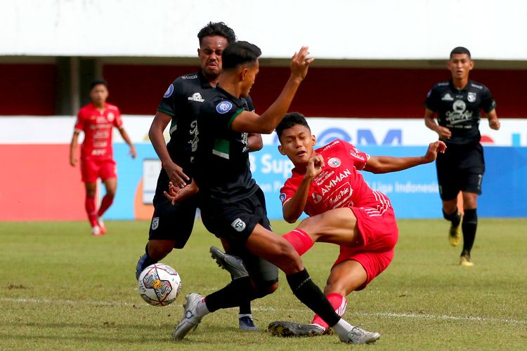 Pemain Persija Jakarta Ginanjar Wahyu Ramadhani menendang bola diantara pemain Persebaya Surabaya saat pertandingan pekan ke-15 Liga 1 2022-2023 yang berakhir dengan skor 1-1 di Stadion Maguwoharjo Sleman, Jumat (16/11/2022) sore.