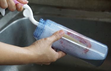 Ilustrasi mencuci botol minum, mencuci botol air minum. 