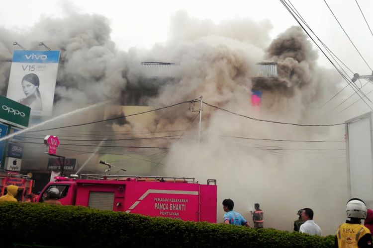 Petugas pemadam kebakaran memadamkan api yang membakar lima ruko tiga lantai di Jalan Tanjungpura Pontianak, Kalimantan Barat, Sabtu (8/6/2019).