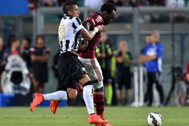 Gelandang Juventus, Arturo Vidal (kiri), berebut bola dengan gelandang AC Milan, Michael Essien, pada pertandingan Trofeo TIM, di Mapei, Reggio Emilia, 23 Agustus 2014.