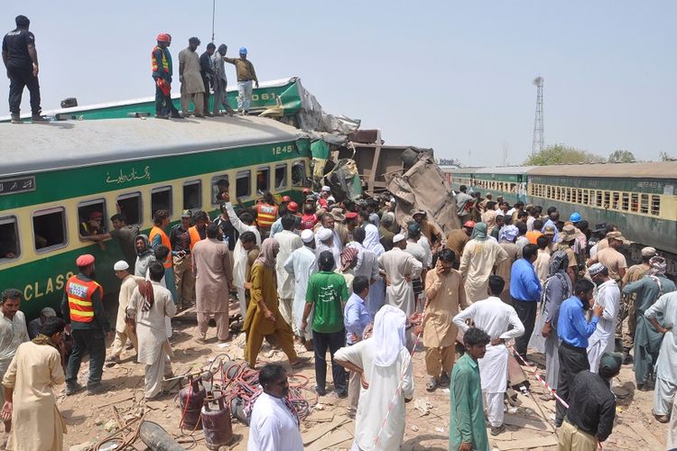 Warga bersama petugas penyelamat berusaha menyelamatkan penumpang dalam kecelakaan kereta api yang terjadi di Pakistan, pada Kamis (11/7/2019).