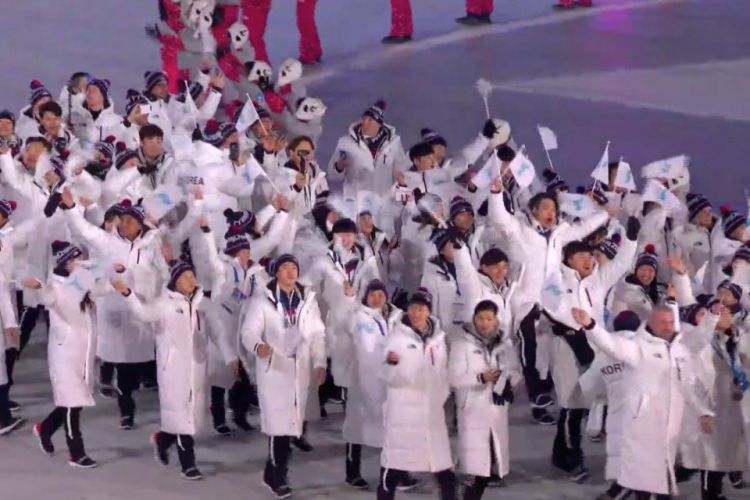 Atlet Korea Selatan dan Korea Utara berjalan berdampingan sambil mengibarkan bendera unifikasi pada seremoni pembukaan Olimpiade Musim Dingin Pyeongchang 2018, di Pyeongchang Stadium, Kamis (9/2/2018).