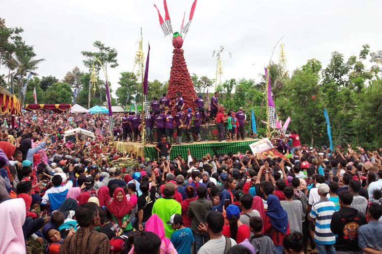 Tumpeng raksasa berisi buah manggis dikelilingi ribuan warga. Tumpengan buah manggis digelar di lapangan Desa Jarak Kecamatan Wonosalam Kabupaten Jombang Jawa Timur, Minggu (24/3/2019). 