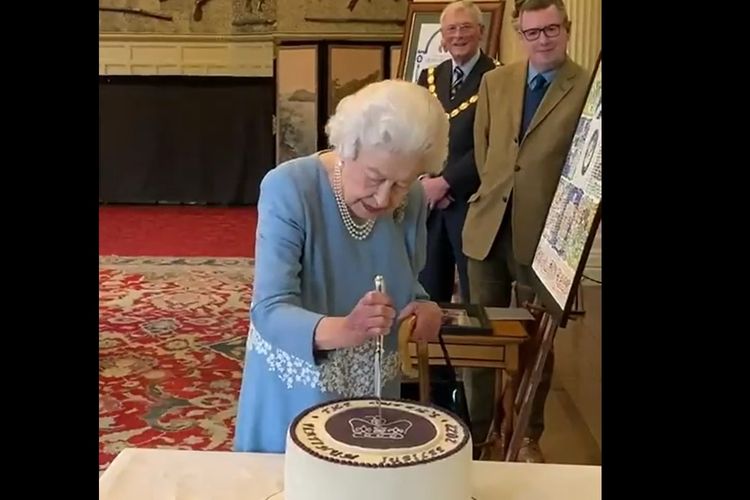 Tangkapan layar Ratu Elizabeth II memotong kue yang dibuat dengan lambang Platinum Jubilee pada malam Accession Day, Sabtu (5/2/2022), yang memperingati 70 tahun memegang takhta Kerajaan Inggris di Sandringham Estate.