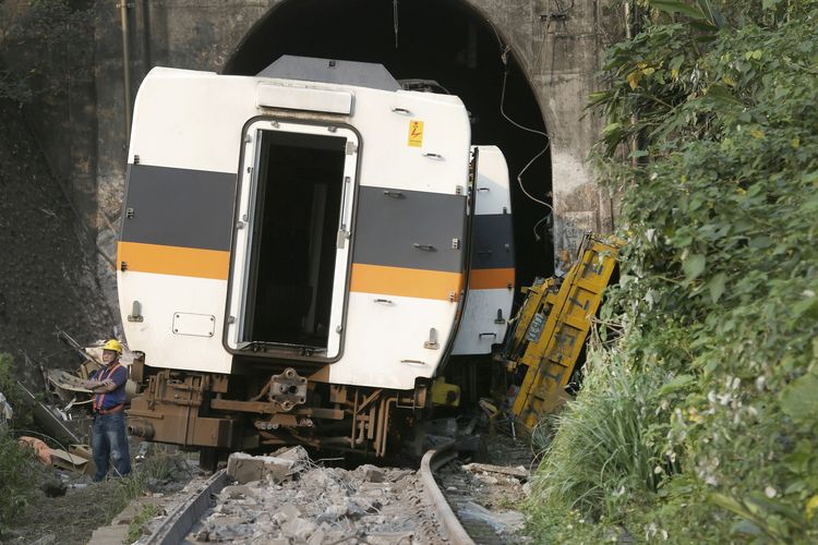 Seorang pekerja pada Sabtu (3/4/2021) berdiri di belakang gerbong kereta Taiwan yang anjlok di kota Hualien. Kecelakaan kereta Taiwan terjadi akibat gerbong anjlok setelah bertabrakan dengan kendaraan yang turun mundur tanpa pengemudi dari atas bukit. Insiden ini menewaskan setidaknya 50 orang.