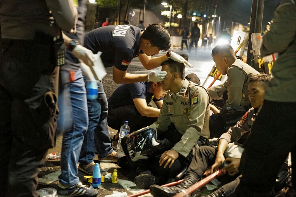 Seorang polisi yang terluka sedang diobati setelah terjadi bentrok dengan massa pengepung kantor YLBHI, Jakarta Pusat, Senin (18/9/2017) dini hari.