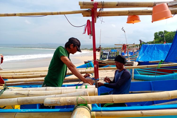 Nelayan memperbaiki jaring di Pantai Santolo Garut yang menjadi salahsatu objek wisata pantai di Garut yang banyak dijadikan destinasi wisata wisatawan.