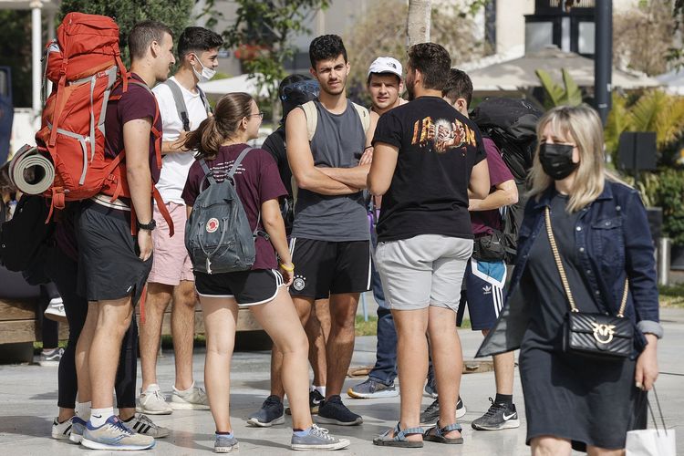 Para pemuda bergerombol di jalanan Tel Aviv, Israel, pada 18 April 2021. Pemerintah Israel resmi mencabut aturan mengenakan masker setelah hampir seluruh populasi dewasa mereka menerima vaksin Covid-19.