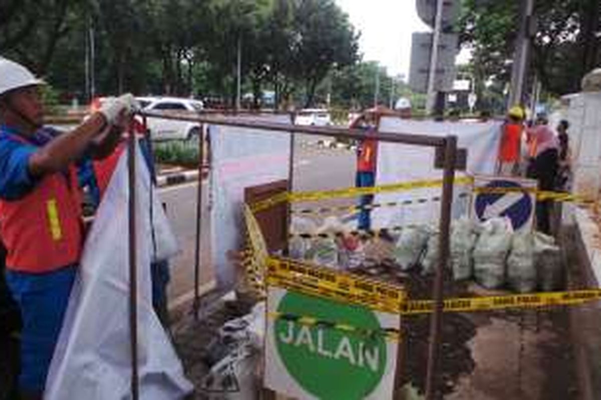 Beberapa petugas dari PLN Disjaya terlihat memasang banner pada pekerjaan
gorong-gorong. PLN akan menyusuri gorong-gorong di Jalan Medan Merdeka
Selatan untuk membuktikan apakah kabel yang menghambat saluran air
merupakan kabel PLN. Foto diambil Sabtu (5/3/2016).
