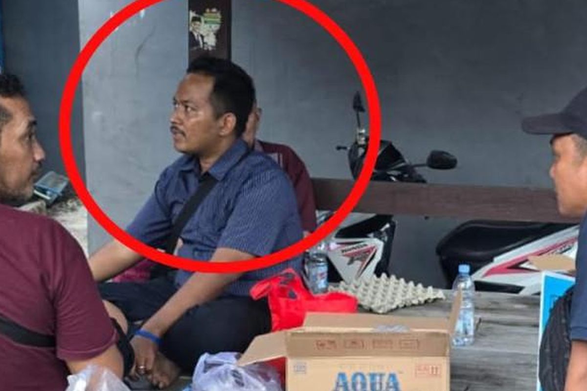 Panit III Subdit III Jatanras Ditreskrimum Polda Jatim AKP Fauzi (kaos ungu) nongkrong dengan sosok Bibi alias M Fawaid (27), pelaku pembunuhan Hj Mirza, di gazebo depan rumah korban seraya menyaksikan proses olah TKP yang dilakukan penyidik Tim Jatanras Ditreskrimum Polda Jatim dan Satreskrim Polres Pasuruan pada Senin (14/7/2025) siang. 
