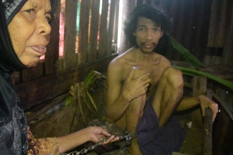 Sukri dalam Kondisi rantai terpasang di kaki saat dibawakan makann oleh ibunya Hindong, Senin (17/01/2022.