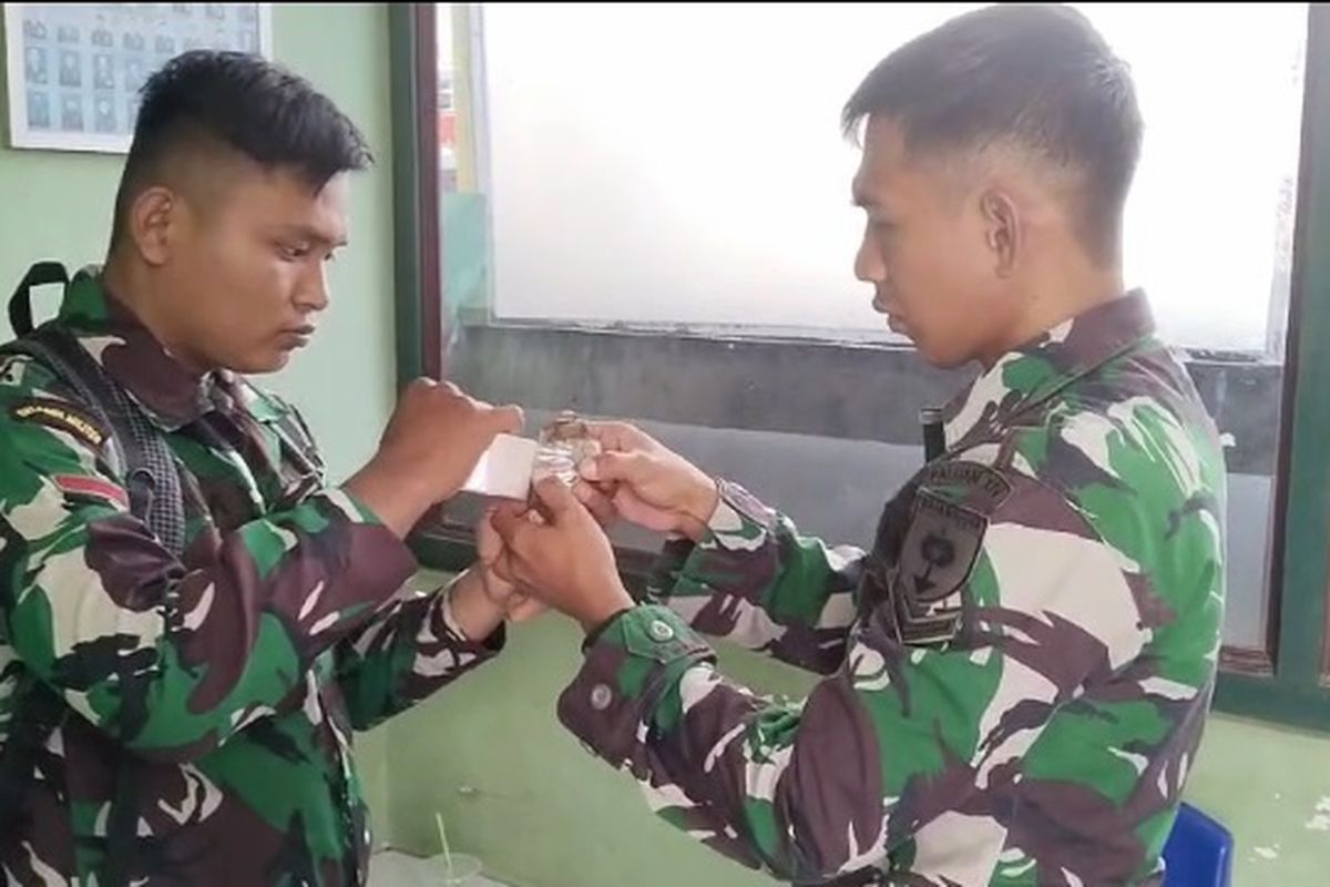 Dua personel TNI Koramil 1403-03/Belopa menerima sebuah granat jenis nenas yang diserahkan Imran Yogi warga Kelurahan Tanamanai, Kecamatan Belopa, Kabupaten Luwu, Sulawesi Selatan, Minggu (14/7/2024).