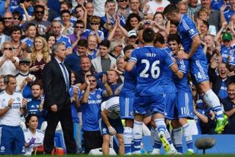 Pelatih Chelsea, Jose Mourinho (kiri) menyaksikan para pemainnya saat tengah merayakan gol Frank Lampard ke gawang Hull City pada lanjutan Premier League di Stamford Bridge, Minggu (18/8/2013). 