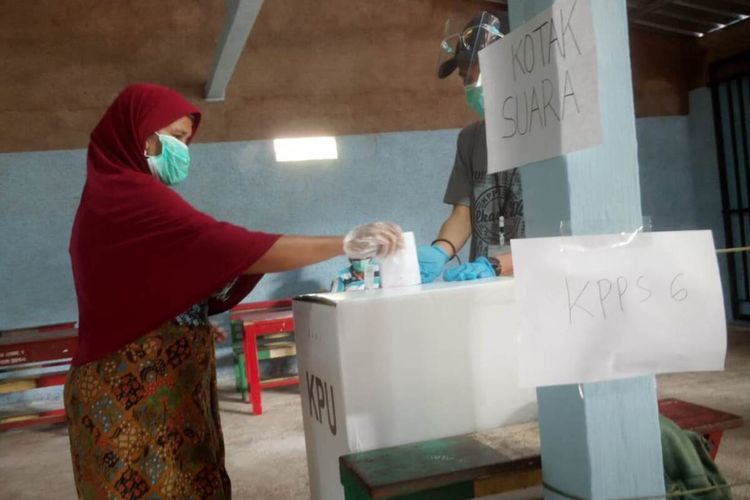 Seorang warga Desa Bunisari, Kecamatan Warungkondang, Kabupaten Cianjur, Jawa Barat, memasukkan surat suara usai mencoblos saat pemungutan suara ulang Pilkada Cianjur 2020, Minggu (13/12/2020).