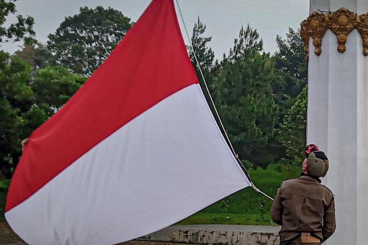 Satpol PP Bandung Barat memasang bendera merah putih yang baru setelah bendera sobek berkibar seharian.