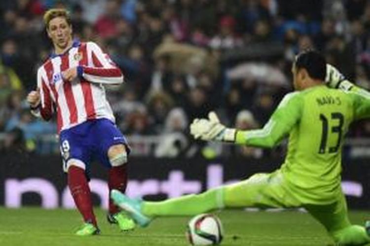 Striker Atletico Madrid, Fernando Torres (kiri), mencetak gol ke gawang Real Madrid yang dikawal Keylor Navas (kanan). Torres mencetak dua gol saat Atletico menahan Madrid, 2-2, pada pertemuan kedua babak 16 besar Copa del Rey 2014-15 di Santiago Bernabeu, Madrid, Kamis (15/1/2015).