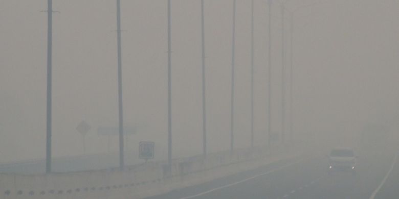 Jalan tol Palindra diselimuti kautvasap tebal sehingga jarak pandang menjadi terbatas. Kendaraan yang melintas nyaris tak terlihat tertutup kabut asap, Selasa (15/10/2019). 