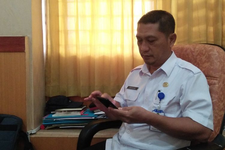 Kepala Dinas Kependudukan dan Catatan Sipil Kabupaten Gresik, Khusaini, saat menunjukkan aplikasi Poedak dari handphone miliknya.