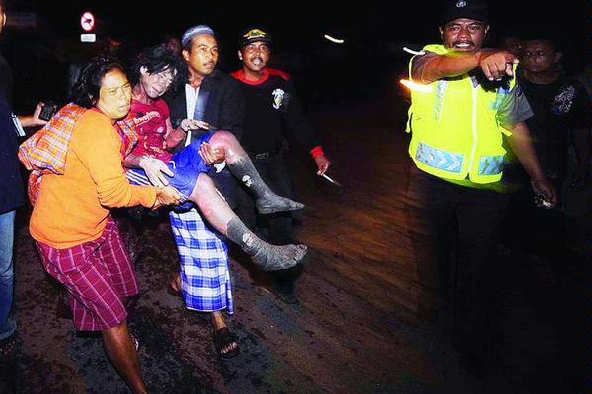 Warga mengevakuasi salah satu korban terjangan awan panas Gunung Merapi di Dusun Kinahrejo, Desa Umbulharjo, Cangkringan, Sleman, DI Yogyakarta, Selasa (26/ 10) petang, menyusul meletusnya gunung itu. Banyak korban luka bakar dan meninggal yang ditemukan di tempat ini. Para korban sulit dievakuasi karena tertutup abu panas.