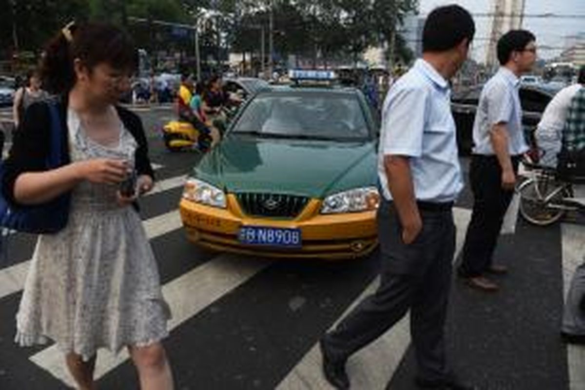 Sebuah taksi terlihat mendesak maju meski sejumlah warga tengah melintasi zebra cross. Ketidakdisiplinan seperti inilah yang coba diperbaiki pemerintah kota Beijing, China.