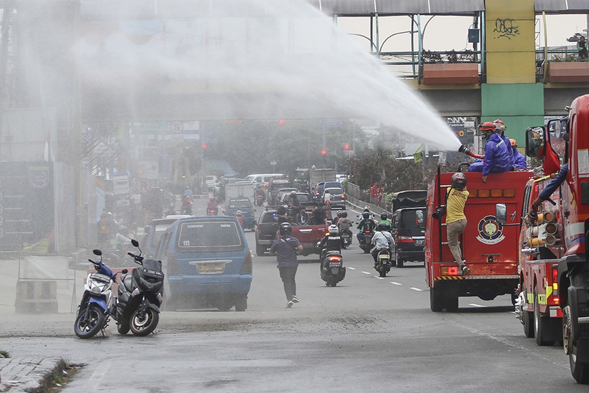 Petugas pemadam kebakaran menyemprotkan cairan disinfektan di jalan Margonda Raya, Depok, Jawa Barat, Senin (23/3/2020). Penyemprotan disinfektan di jalan protokol dan fasilitas umum di kota tersebut guna mencegah penyebaran virus corona atau COVID-19.
