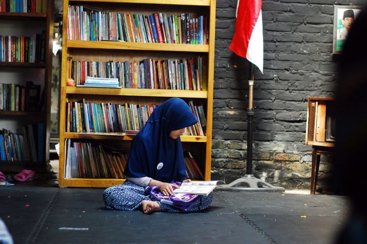 Seorang anak sedang membaca buku di sanggar Ruang Kreatifitas Anak Tanah Ombak, Kampung Purus 3, Kota Padang, Sumatera Barat, Minggu (16/7/2017). Tanah Ombak menjadi tempat bagi anak-anak di kampung tersebut untuk belajar karena mayoritas mereka berasal dari kalangan yang secara ekonomi kurang beruntung. 