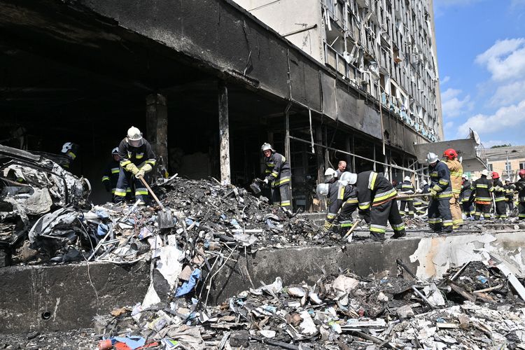 Petugas pemadam kebakaran menyisir puing-puing bangunan yang hancur akibat serangan Rusia di kota Vinnytsia, Ukraina, Kamis (14/7/2022). Setidaknya 20 orang tewas di kota itu dalam perang Rusia vs Ukraina terkini.