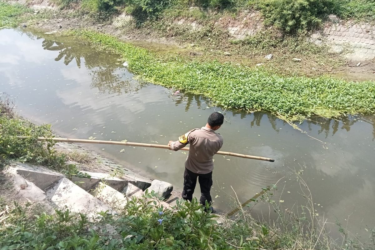 Anggota Polsek Plemahan saat memeriksa sungai Desa Mojoayu, Kecamatan Plemahan, lokasi tenggelamnya dua bocah hingga tewas, Selasa (7/10/2024).