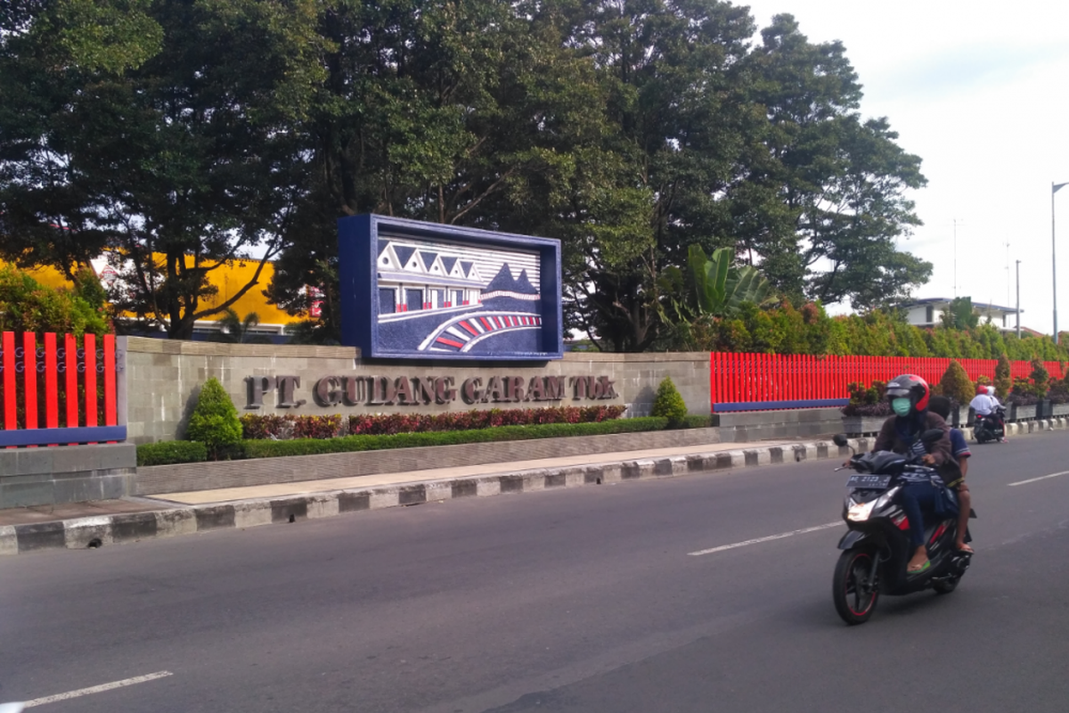 Pengendara motor melintas di depan papan nama sederhana kawasan pabrik rokok PT Gudang Garam Tbk di Kediri, Jawa Timur.