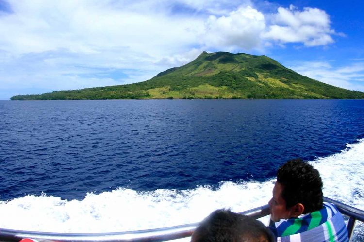 Kapal penumpang melintas di depan Gunung Api Ruang di Kabupaten Sitaro. Sulawesi Utara.