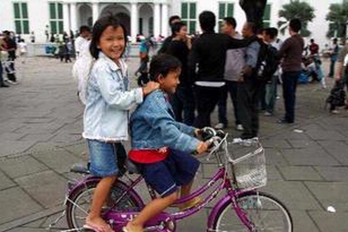 Anak-anak bersepeda mengelilingi kawasan wisata Kota Tua, Jakarta, 